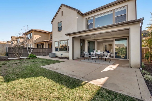 back of house featuring a patio, central AC unit, fence, a yard, and stucco siding