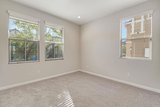 spare room with carpet floors, baseboards, and recessed lighting