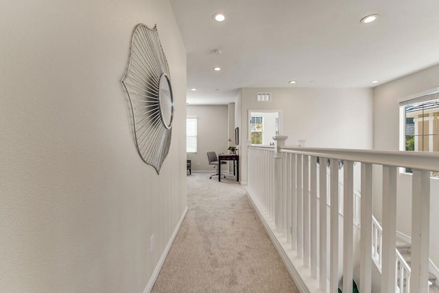 corridor with recessed lighting, light colored carpet, visible vents, and baseboards