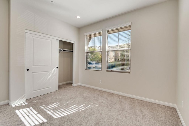 unfurnished bedroom featuring carpet floors, recessed lighting, a closet, and baseboards