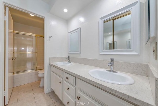 full bathroom featuring double vanity, toilet, tile patterned floors, and a sink