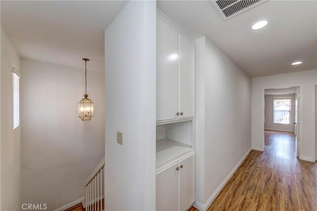 hallway with visible vents, recessed lighting, baseboards, and light wood-style floors