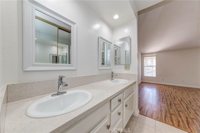 bathroom featuring tile patterned floors, double vanity, baseboards, and a sink