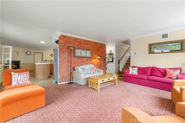 carpeted living room with visible vents, stairway, and ornamental molding