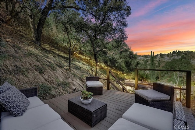 deck at dusk featuring an outdoor hangout area