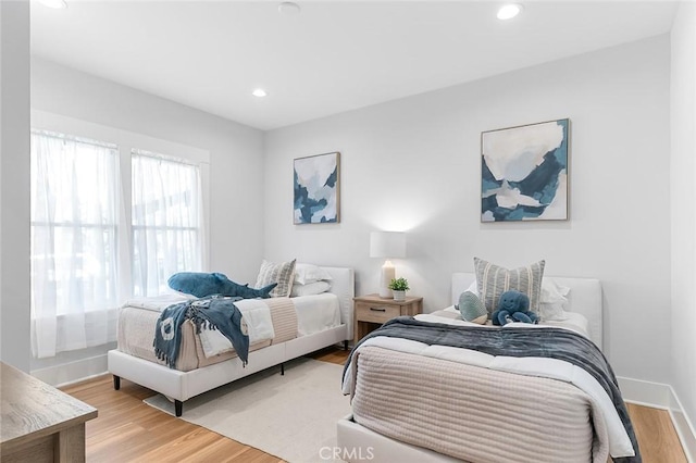 bedroom featuring light wood-type flooring, baseboards, and recessed lighting