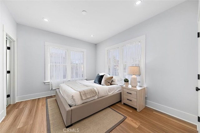 bedroom featuring light wood finished floors, recessed lighting, and baseboards