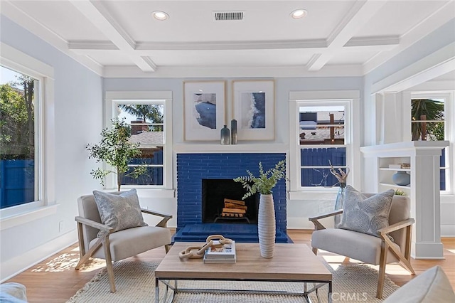 sunroom with beam ceiling, coffered ceiling, and a fireplace