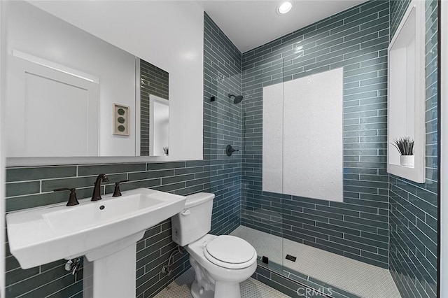 full bath with tile walls, toilet, tile patterned flooring, a tile shower, and backsplash