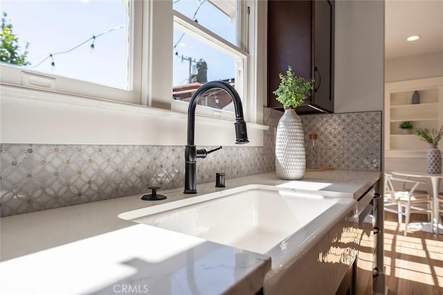 interior details featuring dishwasher, tasteful backsplash, and a sink