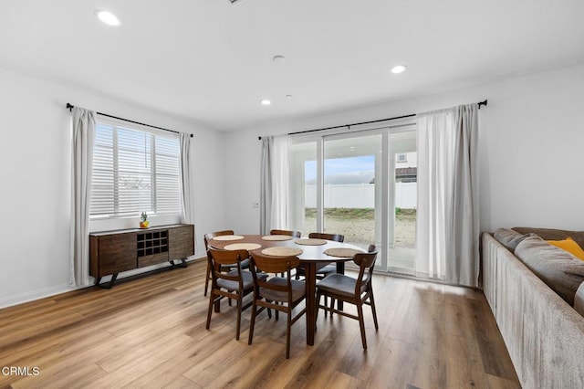 dining room with baseboards, light wood-style flooring, and recessed lighting