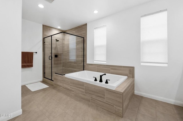 bathroom featuring a shower stall, baseboards, and a bath