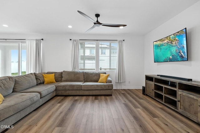 living room featuring baseboards, wood finished floors, a ceiling fan, and recessed lighting