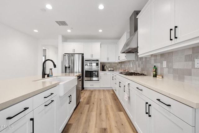 kitchen with recessed lighting, visible vents, light wood-style floors, appliances with stainless steel finishes, and decorative backsplash