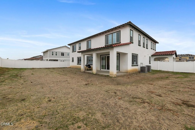 rear view of house with fence private yard, a tile roof, a patio area, and stucco siding