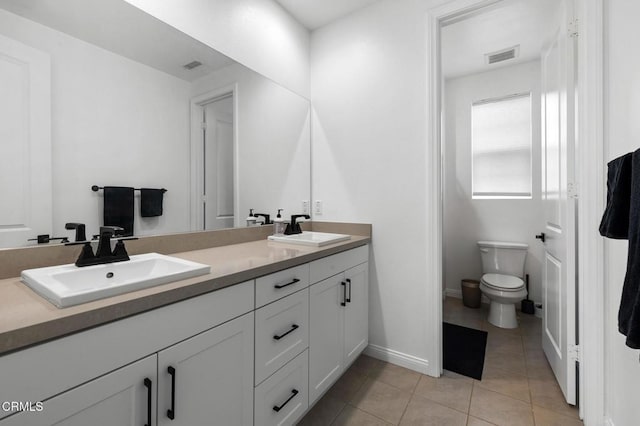 bathroom with tile patterned flooring, visible vents, a sink, and double vanity