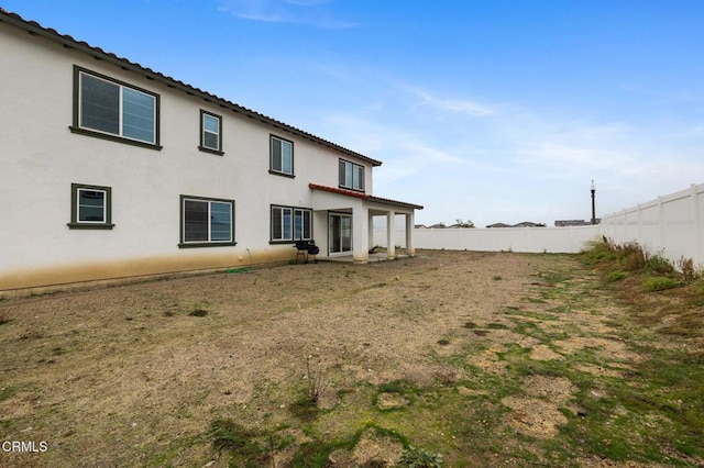 back of property featuring fence and stucco siding