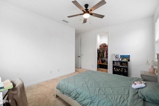 bedroom featuring carpet floors, visible vents, baseboards, a closet, and a walk in closet