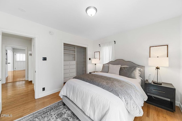 bedroom featuring light wood finished floors, a closet, and baseboards