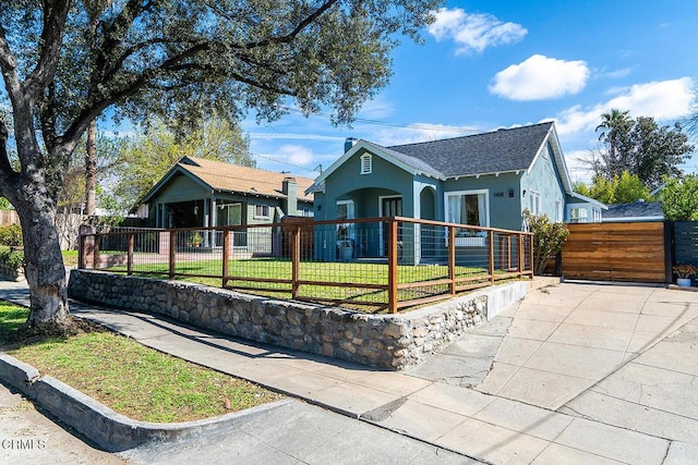 view of front of property with a fenced front yard, a front yard, a gate, and stucco siding