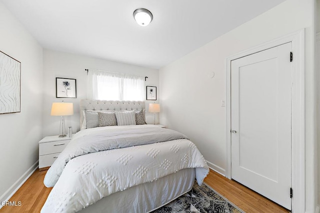 bedroom with light wood finished floors and baseboards