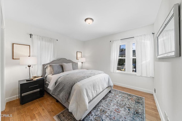 bedroom with baseboards and wood finished floors