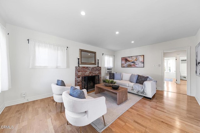 living room with a healthy amount of sunlight, light wood-type flooring, a fireplace, and recessed lighting