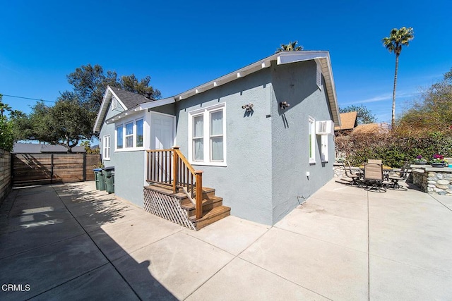 exterior space with outdoor dining space, a patio, fence, and stucco siding