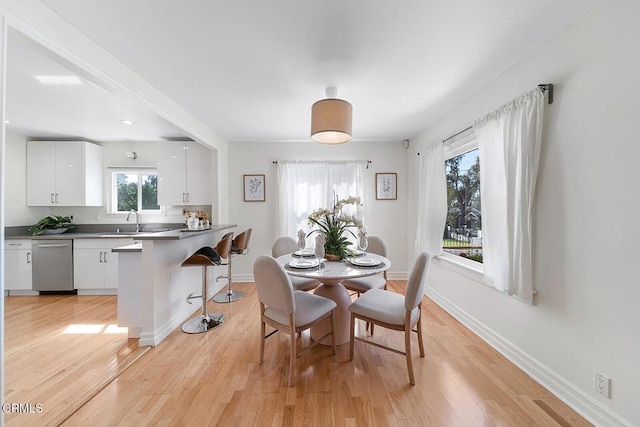 dining area with light wood-type flooring and baseboards