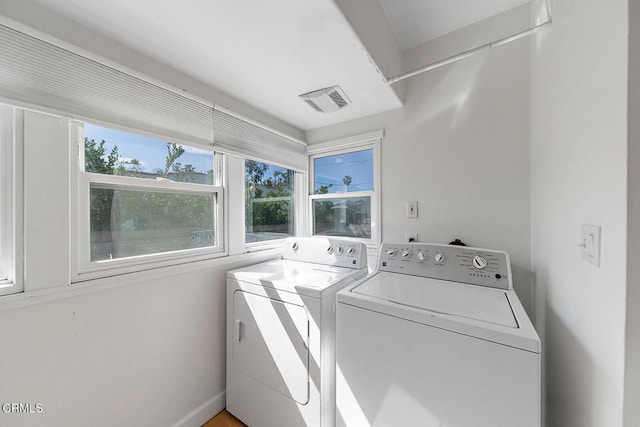 washroom featuring laundry area, washing machine and dryer, and visible vents