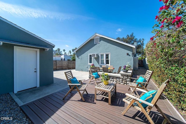 wooden deck featuring outdoor dining area and a fenced backyard