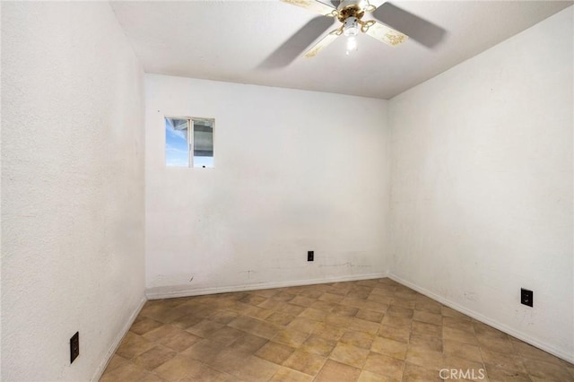 spare room featuring ceiling fan and baseboards