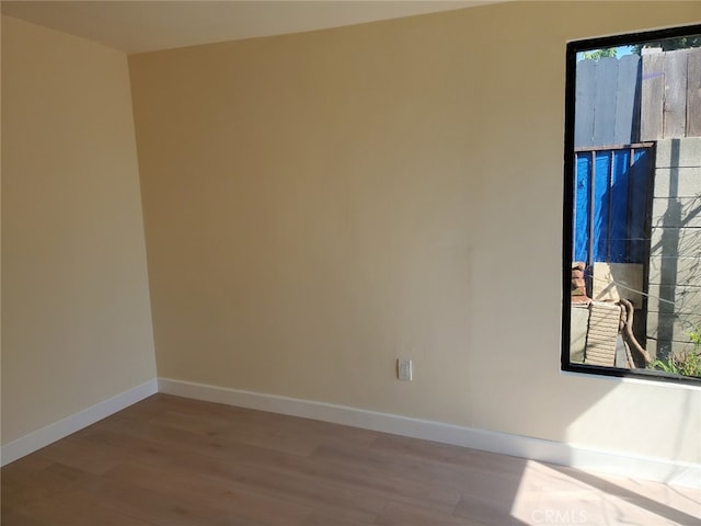 spare room featuring wood finished floors and baseboards