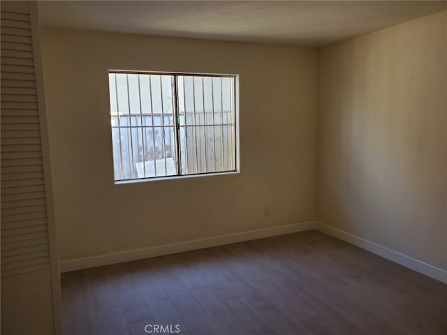 unfurnished room featuring wood finished floors and baseboards