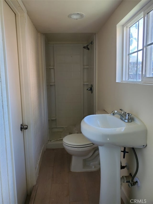 full bathroom with toilet, a shower stall, and wood finished floors