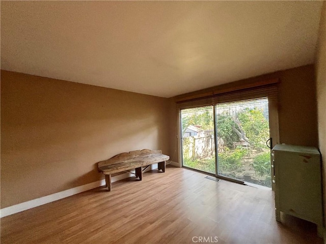 interior space featuring light wood-type flooring, baseboards, and visible vents