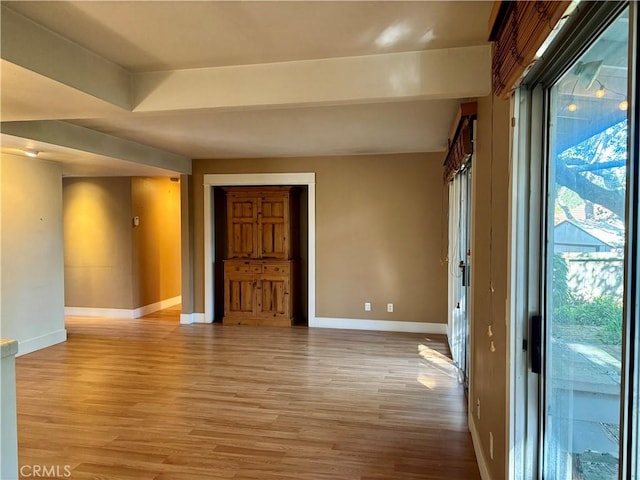 empty room featuring light wood finished floors and baseboards