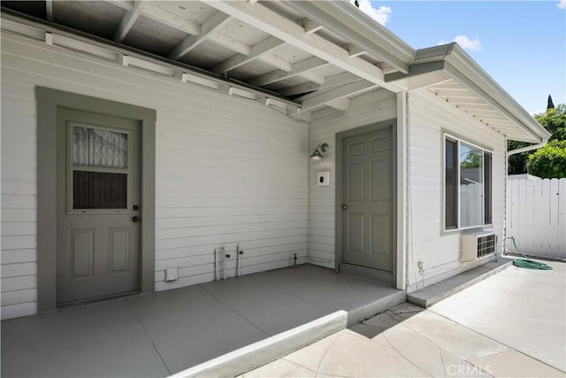 doorway to property featuring fence