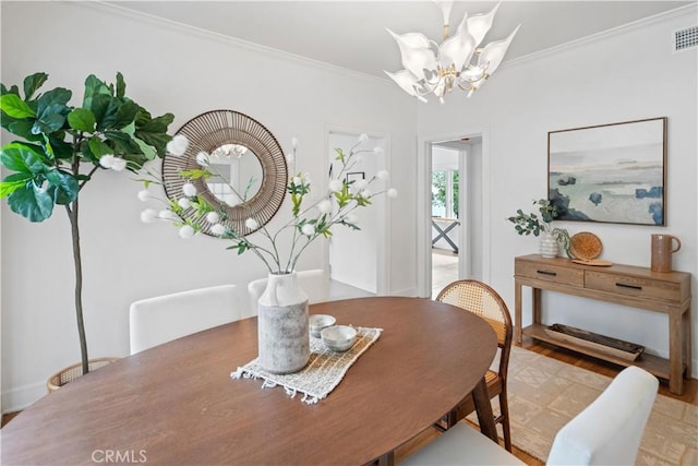 dining room with wood finished floors, visible vents, crown molding, and an inviting chandelier