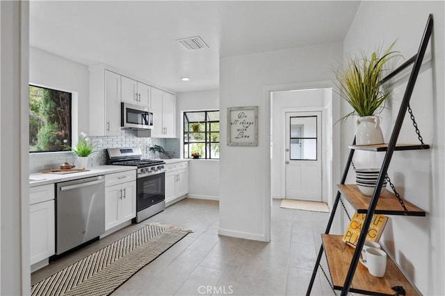 kitchen with light countertops, visible vents, decorative backsplash, appliances with stainless steel finishes, and white cabinets