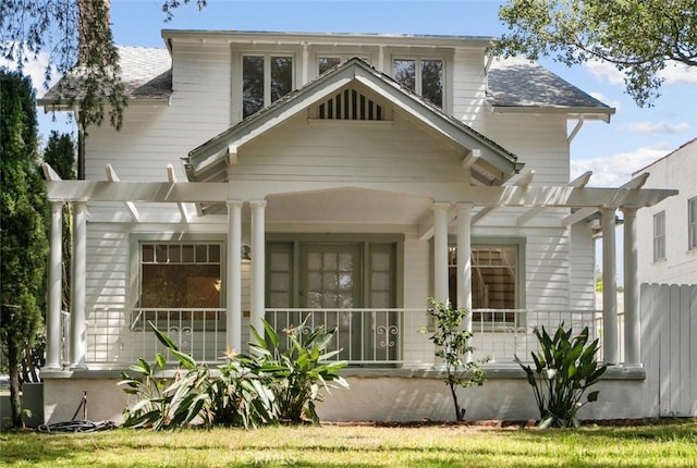 back of house featuring a porch, a shingled roof, and a pergola