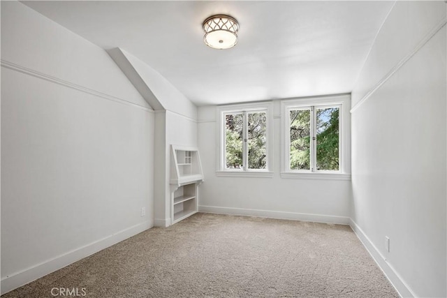 spare room featuring carpet and baseboards