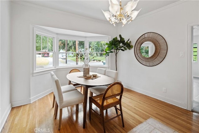 dining room featuring ornamental molding, light wood-style flooring, and baseboards