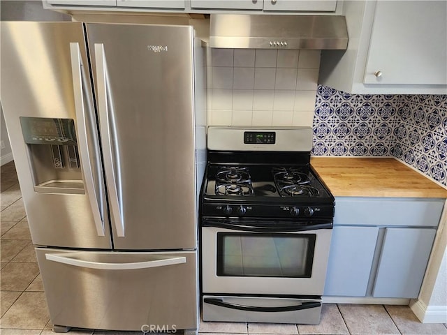 kitchen featuring light tile patterned floors, extractor fan, stainless steel appliances, wood counters, and decorative backsplash