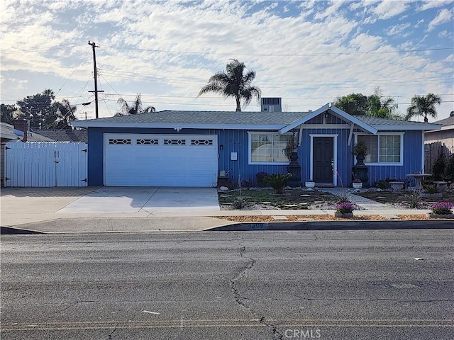 ranch-style house with an attached garage, cooling unit, fence, and concrete driveway