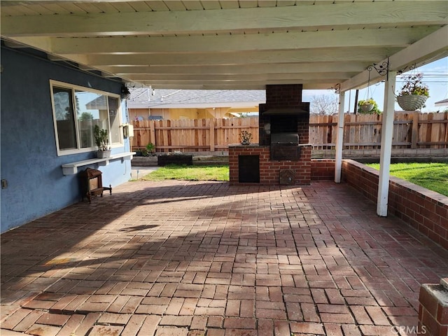 view of patio featuring an outdoor brick fireplace, fence, and a grill