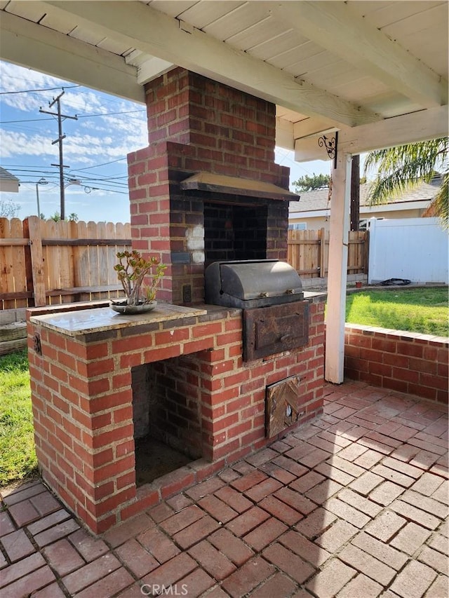 view of patio / terrace with area for grilling, fence, and an outdoor kitchen