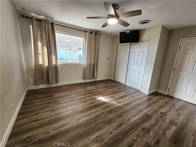 unfurnished bedroom with visible vents, a closet, baseboards, and dark wood-style flooring