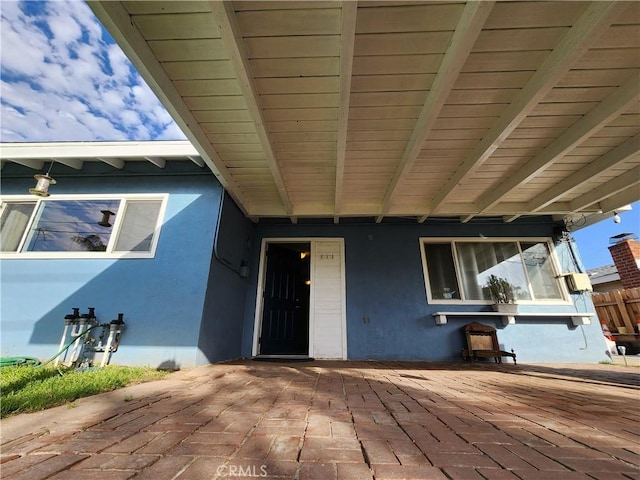 entrance to property featuring a patio area and stucco siding