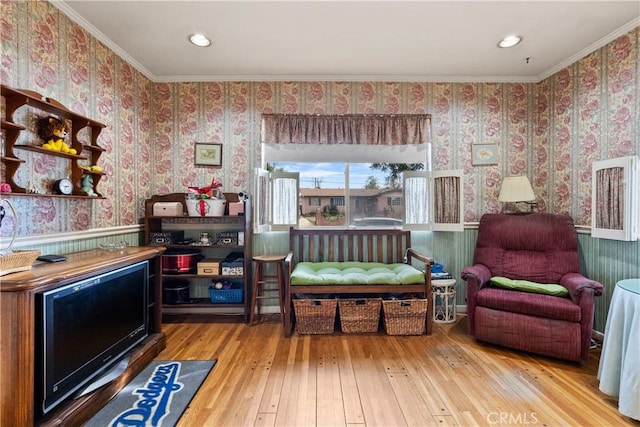 sitting room featuring wallpapered walls, ornamental molding, and hardwood / wood-style flooring